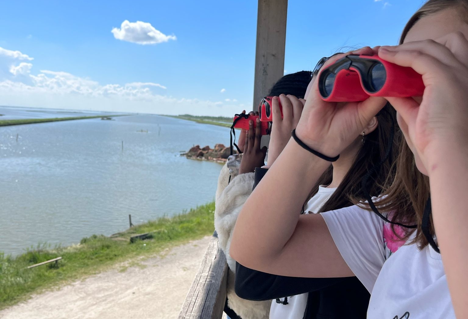 laguna-scuola-1 bambine che guardano con binocolo il delta del po, progetto la laguna va a scuola